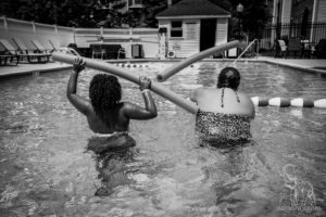 mother and daughter play in the pool